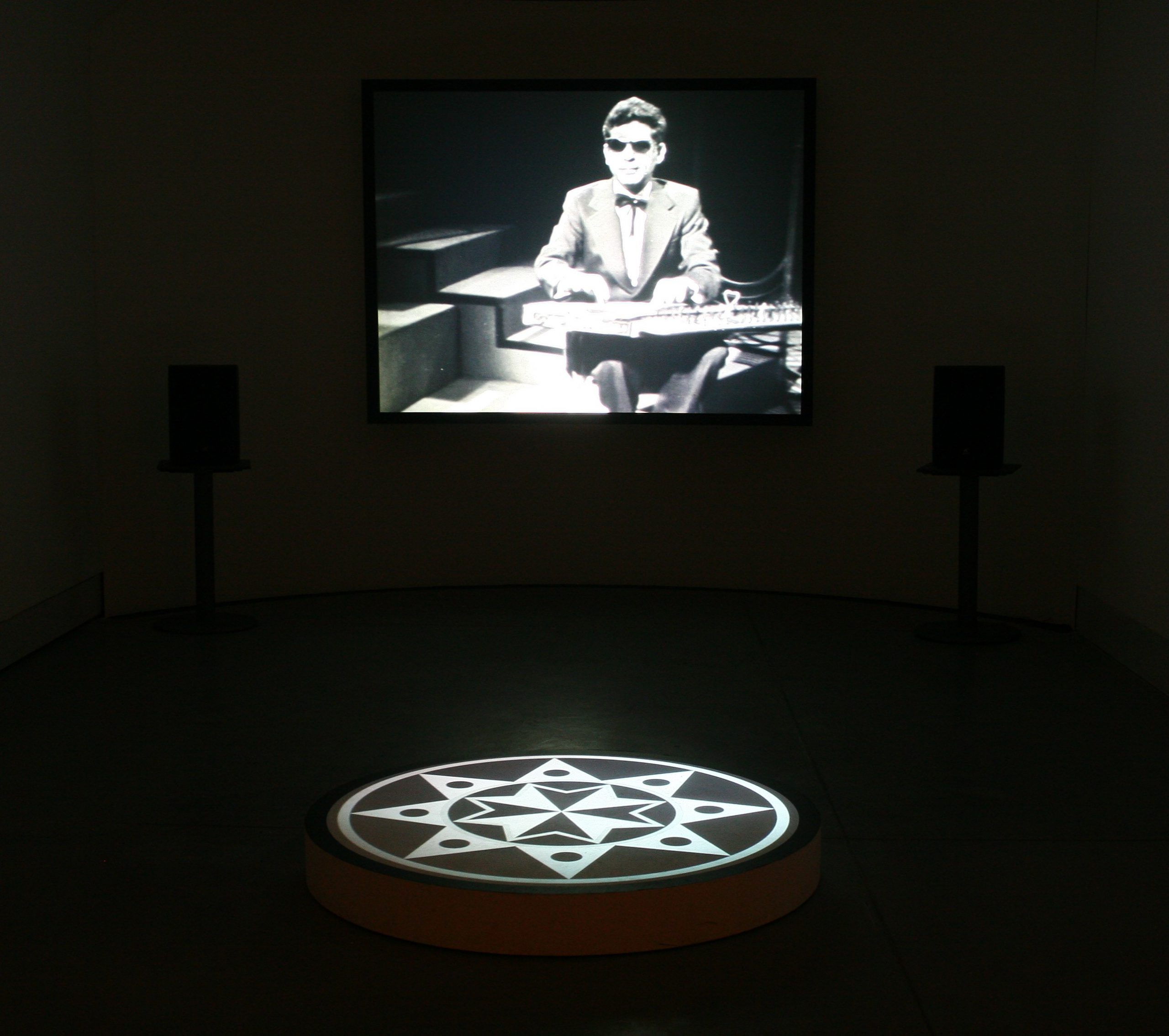 "A Great Joy Tonight", 2009, two-channel video installation projected on a wall and a round stage, black&white, stereo sound, duration 10:43 min, dimantions variable