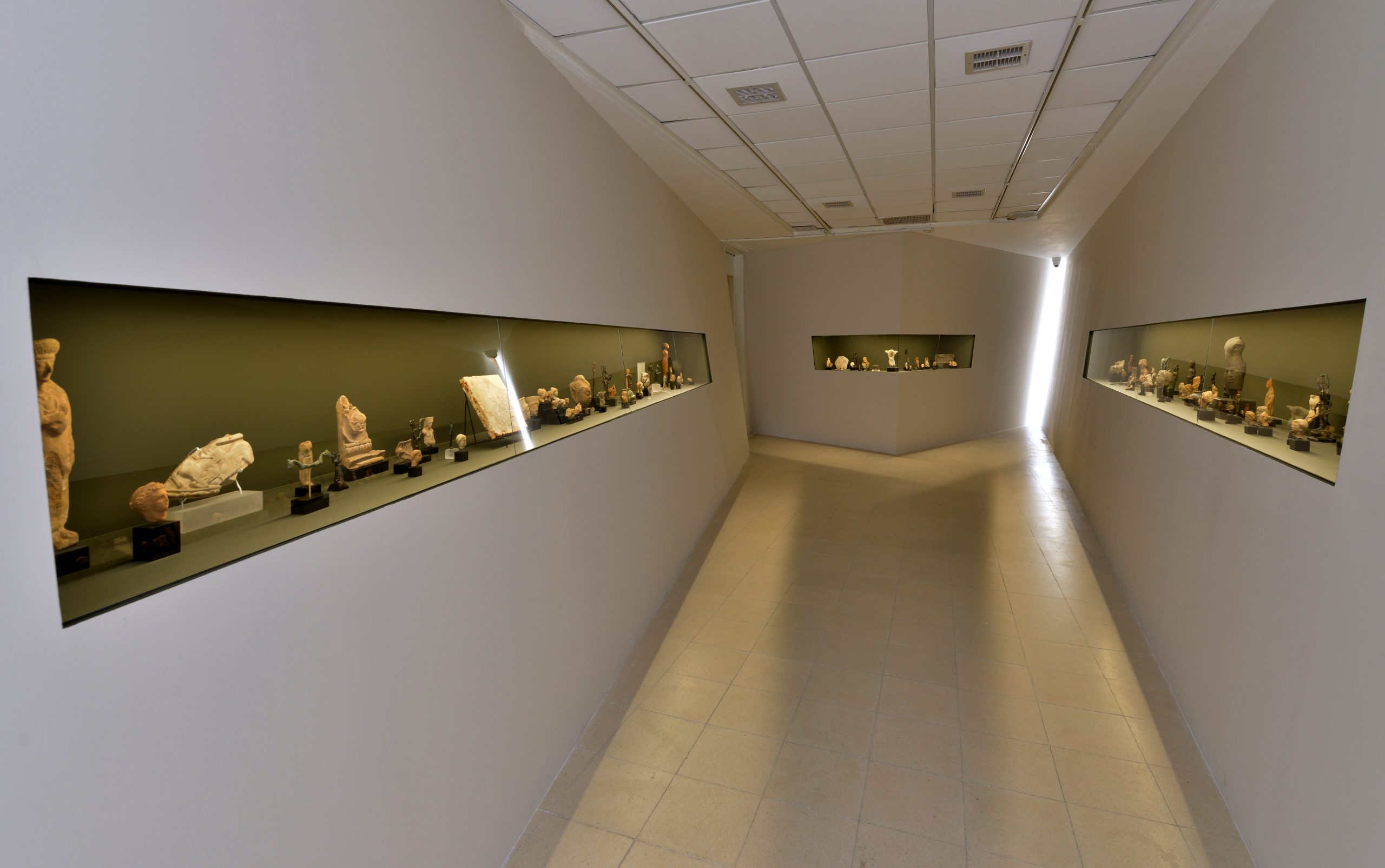"The Collection", 2021, an installation built as a unique architectural space consisting of four diagonal plaster walls and three glass display cabinets in which the original collection of Wilfred Israel is displayed as one group with no hierarchies or additional labels,
dimentions 17m x 5m x 3m